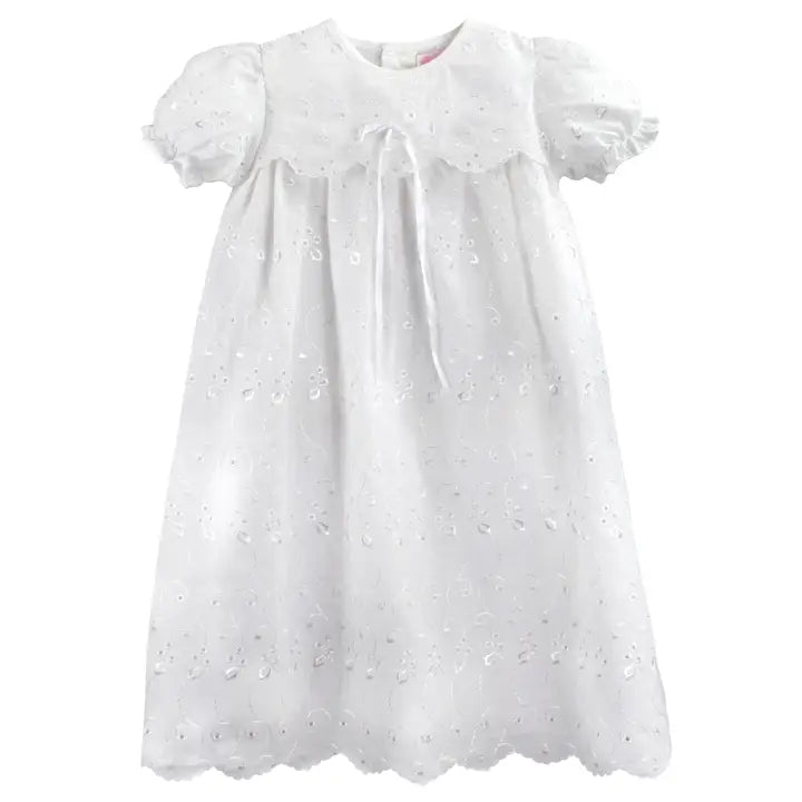 White baby dress with lace details on a white background