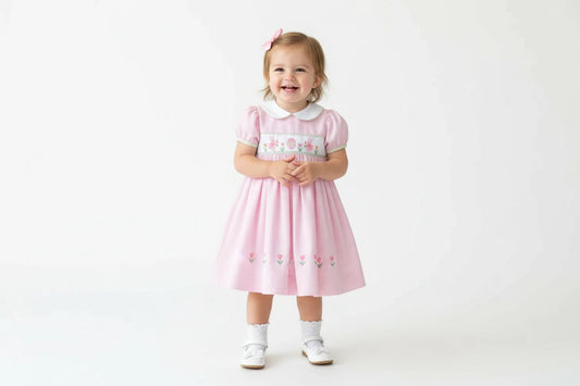 Pink striped dress with embroidered design on a white background