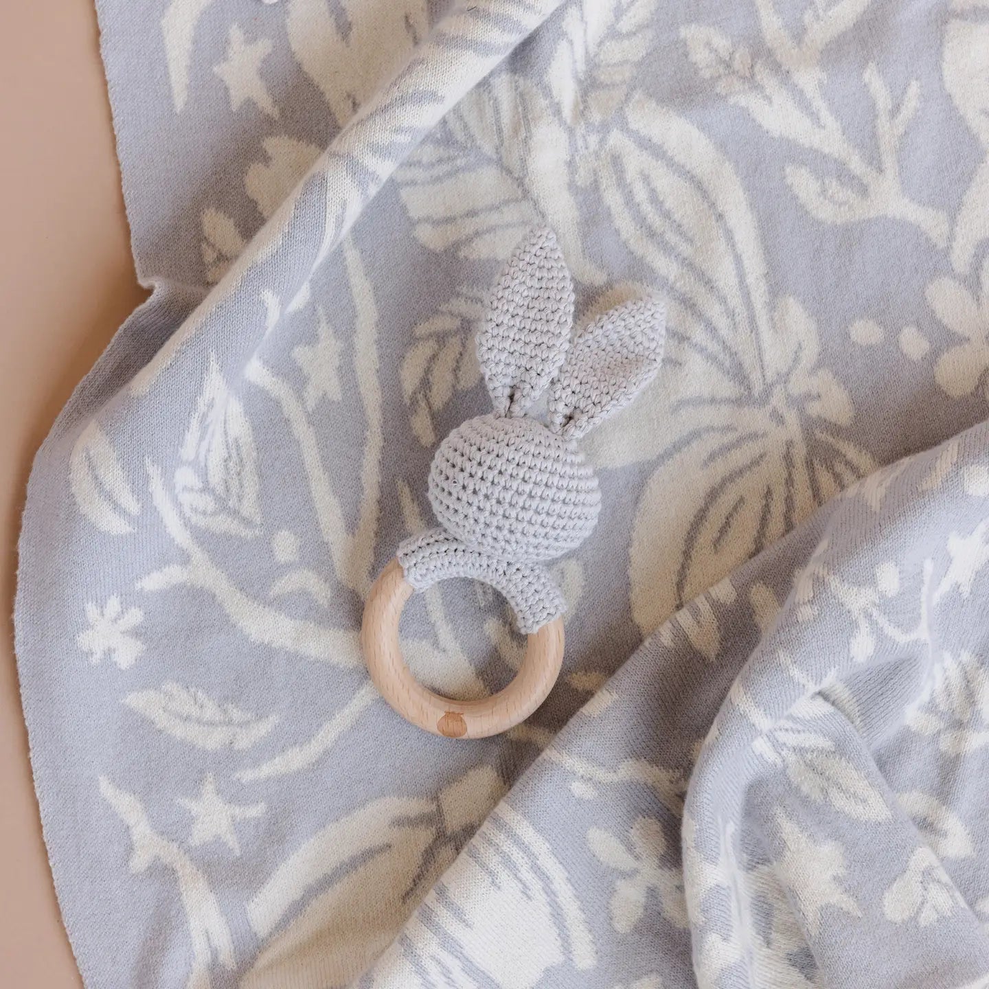 Textured teething ring on a floral-patterned blanket