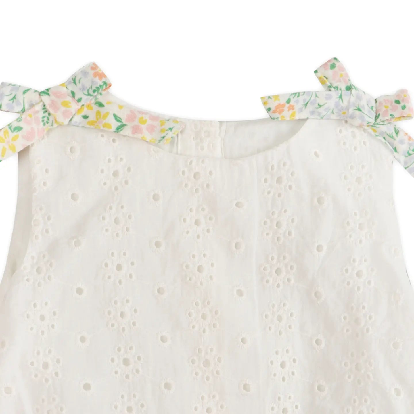 White eyelet dress with floral bow straps on a white background