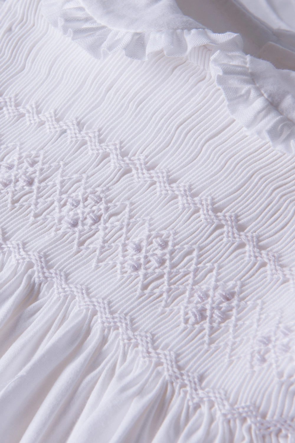 Close-up of a textured white fabric with ruffled edge