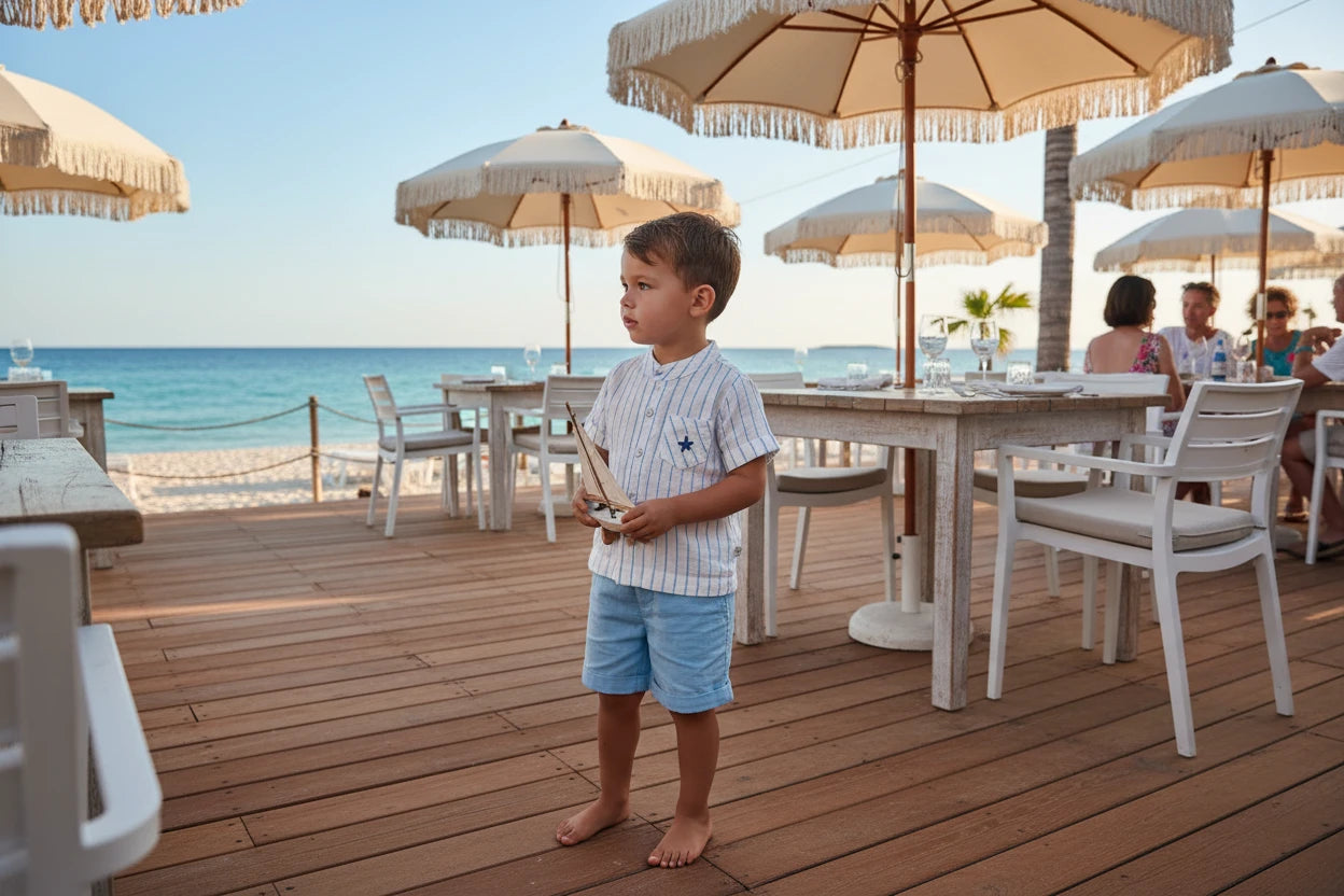 Children's outfit with striped shirt and light blue shorts on a white background