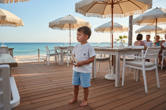 Children's outfit with striped shirt and light blue shorts on a white background